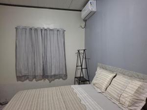 a white bedroom with a bed and a window at M&A Hospedagem in Cruzeiro do Sul