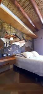 a bedroom with a bed and a rock wall at Ocres de mi Tierra in Tilcara