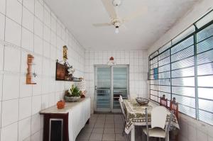 a kitchen with a table and chairs and a window at CASA com ACOMODAÇÃO para 6 PESSOAS in Guaratinguetá