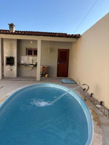 a large blue swimming pool in front of a house at Casa TS Morro Branco in Beberibe