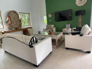 a living room with two couches and a tv at Ubuntu Villa in Ko Phangan