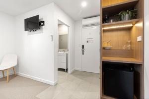 a room with a hallway with a tv and a bathroom at Modern Queen Studio - 6 Mins to Callala Beach in Callala Beach