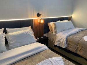 a hotel room with two beds and a lamp at Pousada HG-102-Suíte in Vila Nova do Sul