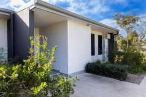 a white house with plants in front of it at Modern Queen Studio - 6 Mins to Callala Beach in Callala Beach +8 photos
