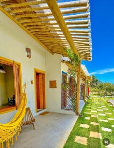 a patio with a hammock outside of a house at Casa Mangaba da Praia in Prado