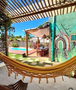 a hammock under a pergola next to a pool at Casa Mangaba da Praia in Prado