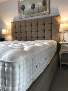 a large white bed in a room with a mirror at The Old Rectory B&B in Salisbury