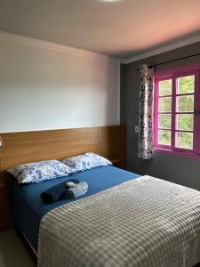 a bedroom with a bed with a stuffed animal on it at Pousada Recanto Barão de Biguaçu in Biguaçu