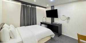 a hotel room with a white bed and a television at Hotel Barley Field Seoknam in Incheon +34 photos