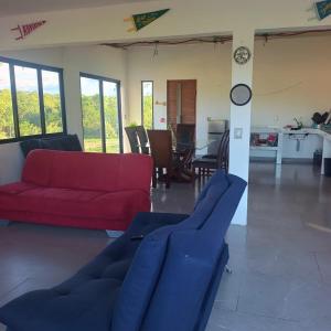 a living room with a red couch and a table at Quinta Bello Cielo in Montemorelos