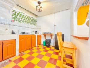 a kitchen with orange and yellow cabinets and a checkered floor at Apto cerca al parque de Jardín in Jardin +10 photos