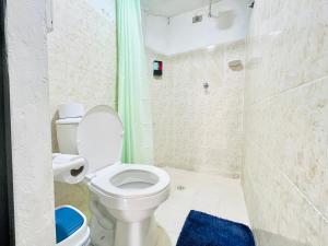 a bathroom with a white toilet and a blue rug at Apto cerca al parque de Jardín in Jardin