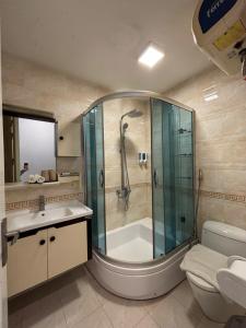 a bathroom with a shower and a toilet and a sink at Valoria Legend Hanoi Hotel in Hanoi