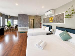 a hotel room with two beds and a living room at Valoria Legend Hanoi Hotel in Hanoi