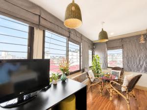 a living room with a flat screen tv and a table at Valoria Legend Hanoi Hotel in Hanoi