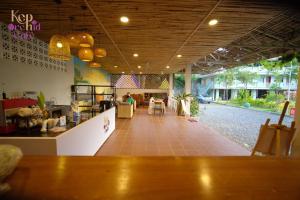 a restaurant with a counter and a table and chairs at Kep Orchid Cafe in Phumĭ Dâmnăk Châng'aeur