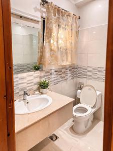 a bathroom with a toilet and a sink at The Corvane Residence in Islamabad