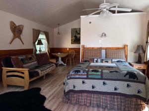 a bedroom with a bed and a chair and a table at Denali Fireside Cabin & Suites in Talkeetna