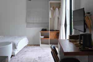 a bedroom with a bed and a desk and a tv at Hillside Koh Samui in Ban Khlong Mae Nam