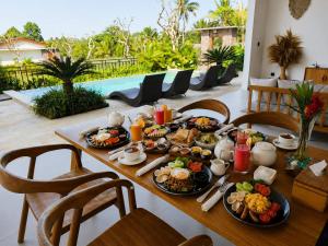 a table with breakfast foods on it in a living room at KAPI Sebatu Villa in Tampaksiring