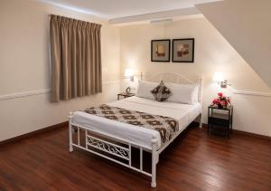 a bedroom with a bed and two lamps and a window at 1775 Adriatico Suites in Manila +107 photos