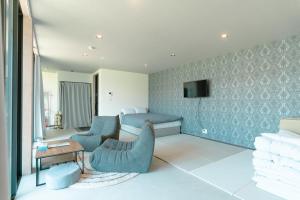 a bedroom with a bed and a couch and a table at AoAsoVilla in Aso