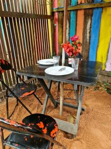 a black table with two plates and flowers on it at Mucajá Glamping com charme a poucos passos da Ilha in Alter do Chao