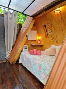 a bedroom with a bed with two pink pillows on it at Mucajá Glamping com charme a poucos passos da Ilha in Alter do Chao