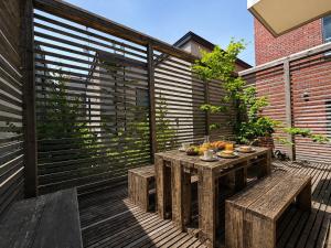 a wooden deck with a table and benches on it at Haus128 in Sapporo