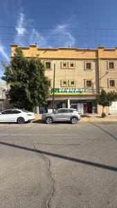 two cars parked in a parking lot in front of a building at الدانه1 in Al Wajh