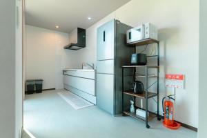 a kitchen with a refrigerator and a sink at AoAsoVilla in Aso