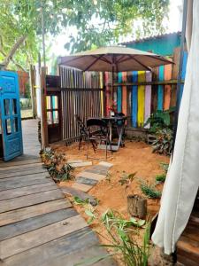 a patio with a table and an umbrella at Mucajá Glamping com charme a poucos passos da Ilha in Alter do Chao