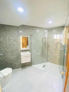 a bathroom with a shower and a toilet and a sink at Grospe Resort Boracay in Boracay