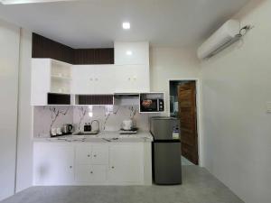 a kitchen with white cabinets and a stainless steel refrigerator at Grospe Resort Boracay in Boracay