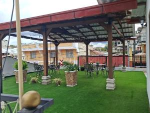 a patio with tables and chairs on the grass at Villa Alissa in Quetzaltenango