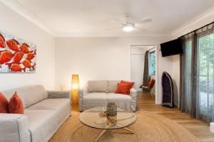 a living room with a couch and a table at Cape Byron Retreat (Adults-Only) in Byron Bay