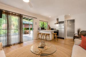 a living room with a couch and a table at Cape Byron Retreat (Adults-Only) in Byron Bay