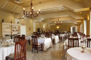 a restaurant with white tables and chairs and chandeliers at Guadacorte Park in Los Barrios