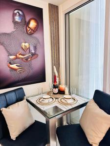 a dining room with a glass table and two chairs at Azure South by Dream Escapade in Manila