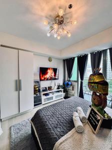 a bedroom with a bed and a tv on a wall at Azure South by Dream Escapade in Manila