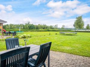 a picnic table with chairs and a field of grass at 5 star holiday home in Ansager in Ansager