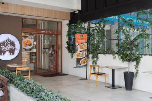 a restaurant with a table and chairs in front of it at Nawin Hotel Donmueang in Thung Si Kan