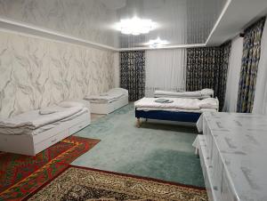 a room with three beds in it with a table at Эко Жайлоо in Kaji-Say