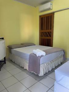 a bedroom with two beds with towels on them at Pousada Taquarí Guaibim in Valença