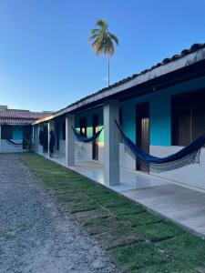 a house with a hammock in front of it at Pousada Taquarí Guaibim in Valença +6 photos