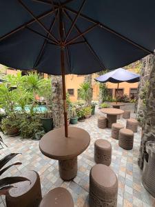 a table and stools with an umbrella on a patio at 1775 Adriatico Suites in Manila