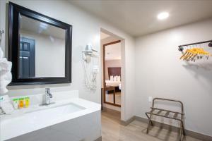 a white bathroom with a sink and a chair at The Inn On 66 Flagstaff in Flagstaff +48 photos