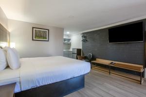 a bedroom with a large bed and a flat screen tv at The Inn On 66 Flagstaff in Flagstaff
