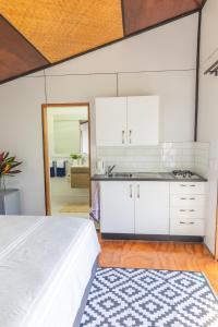 a kitchen with white cabinets and a bed in a room at Ariki Retreat - Adults Only in Rarotonga +41 photos