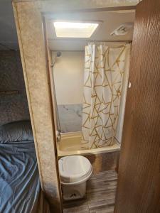 a small bathroom with a toilet and a bed at Casa Rodante Tony 2 in San Felipe